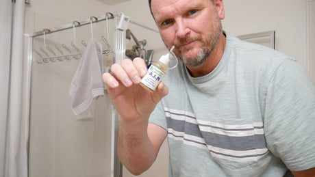 Man holding glue for fixing squeaking creaking glass shower door hinge in real time
