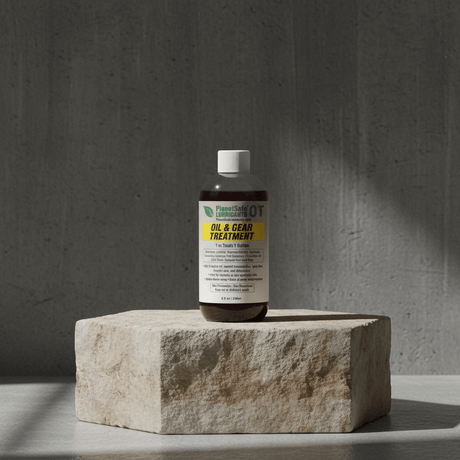 Bottle of oil and gear treatment on a stone block with a gray background